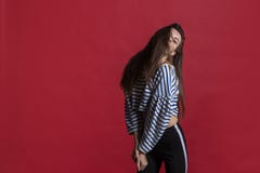 Studio sparato di bella donna adorabile isolata contro una parete rossa vuota dello studio fotografie stock libere da diritti Studio sparato di bella donna adorabile isolata contro una parete rossa vuota dello studio fotografie stock libere da diritti