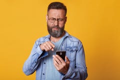Studio strzał w średnim wieku mężczyzna z interesującym pojawieniem, ciemna hairand broda, ubierająca niezobowiązująco używa nowo zdjęcia stock Studio strzał w średnim wieku mężczyzna z interesującym pojawieniem, ciemna hairand broda, ubierająca niezobowiązująco używa nowo zdjęcia stock