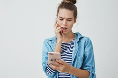 Studio strzelająca zdumiona skołatana śliczna potomstw 25s kobieta sprawdza rachunki spisuje online, marszczący brwi skołatany gr zdjęcia stock Studio strzelająca zdumiona skołatana śliczna potomstw 25s kobieta sprawdza rachunki spisuje online, marszczący brwi skołatany gr zdjęcia stock