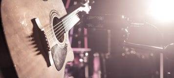 Studiomikrofonen antecknar en närbild för akustisk gitarr Härlig suddig bakgrund av kulöra lyktor royaltyfria foton Studiomikrofonen antecknar en närbild för akustisk gitarr Härlig suddig bakgrund av kulöra lyktor royaltyfria foton