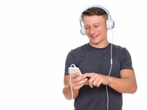 Studioskott av den unga lyckliga Caucasian mannen som anv?nder mobiltelefonen och arkivbilder Studioskott av den unga lyckliga Caucasian mannen som anv?nder mobiltelefonen och arkivbilder