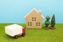 Stuk speelgoed autovrachtwagen en huis op groen gras royalty-vrije stock afbeelding Stuk speelgoed autovrachtwagen en huis op groen gras royalty-vrije stock afbeelding