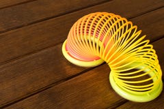 Stuk speelgoed plastic regenboog op een houten lijst Multi-colored spiraal voor royalty-vrije stock foto Stuk speelgoed plastic regenboog op een houten lijst Multi-colored spiraal voor royalty-vrije stock foto