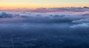 Stunning view of Earth and Heaven: night city beneath blue clouds and golden and pink sky stock photography Stunning view of Earth and Heaven: night city beneath blue clouds and golden and pink sky stock photography