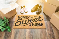 Stuoia benvenuta della casa dolce casa, scatole commoventi, femmina e scarpe del maschio fotografia stock Stuoia benvenuta della casa dolce casa, scatole commoventi, femmina e scarpe del maschio fotografia stock