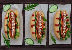 Stwarza ognisko domowe robić hot dog z warzywami, soczystą kiełbasą i arugula, obraz stock Stwarza ognisko domowe robić hot dog z warzywami, soczystą kiełbasą i arugula, obraz stock