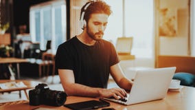 Stylish Guy in Headphones Use Laptop at Workplace royalty free stock photos Stylish Guy in Headphones Use Laptop at Workplace royalty free stock photos
