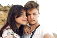 Stylish hipster couple taking selfie and embracing on beach in evening. Happy family relaxing on honeymoon at sea. Summer vacation stock photos Stylish hipster couple taking selfie and embracing on beach in evening. Happy family relaxing on honeymoon at sea. Summer vacation stock photos