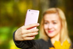 Portrait of cheerful young woman with autumn leafs in front of foliage making selfie stock images Portrait of cheerful young woman with autumn leafs in front of foliage making selfie stock images