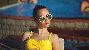 Stylish and young woman in sunglasses sunbathing in the sunshine summertime stock video footage Stylish and young woman in sunglasses sunbathing in the sunshine summertime stock video footage