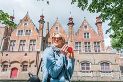 Stylish young female tourist takes a selfie on a mobile phone in Bruges, Belgium. royalty free stock photography Stylish young female tourist takes a selfie on a mobile phone in Bruges, Belgium. royalty free stock photography