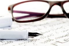 Stylo-plume blanc sur la lettre, verres derrière image stock Stylo-plume blanc sur la lettre, verres derrière image stock