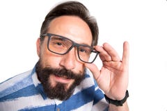 Stäng sig upp av den intelligenta skäggiga mannen som ser dig till och med exponeringsglas royaltyfri foto Stäng sig upp av den intelligenta skäggiga mannen som ser dig till och med exponeringsglas royaltyfri foto