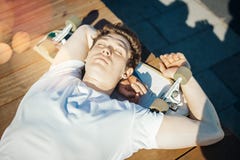 Stäng sig upp av den unga attraktiva mannen som lägger på bänken i parkera royaltyfri bild Stäng sig upp av den unga attraktiva mannen som lägger på bänken i parkera royaltyfri bild