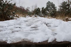 Stäng sig upp av iskalla fotspår i snö på en bygdvandringsled arkivbild Stäng sig upp av iskalla fotspår i snö på en bygdvandringsled arkivbild