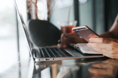 Stäng sig upp av kvinnliga händer genom att använda den smarta telefonen, medan arbeta på datoren royaltyfria bilder Stäng sig upp av kvinnliga händer genom att använda den smarta telefonen, medan arbeta på datoren royaltyfria bilder