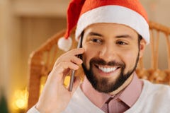 Stäng sig upp av lycklig man i appeller för jultomtenhattdanande royaltyfri fotografi Stäng sig upp av lycklig man i appeller för jultomtenhattdanande royaltyfri fotografi