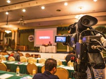 Stäng sig upp den yrkesmässiga videokameran i konferenskorridor eller seminarium royaltyfria bilder Stäng sig upp den yrkesmässiga videokameran i konferenskorridor eller seminarium royaltyfria bilder