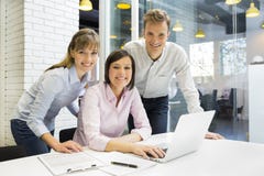 Stående av att le Businessteam i start som ser kameran royaltyfri bild Stående av att le Businessteam i start som ser kameran royaltyfri bild