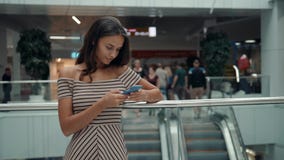 Stående av att le kvinnan som använder smartphonestämmaerkännande Ung Caucasian flicka i flygplatsterminal med bagage stock video Stående av att le kvinnan som använder smartphonestämmaerkännande Ung Caucasian flicka i flygplatsterminal med bagage stock video