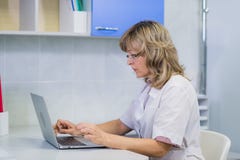 Stående av den medicinska experten på arbete och att se bärbara datorn som arbetar arkivbilder Stående av den medicinska experten på arbete och att se bärbara datorn som arbetar arkivbilder