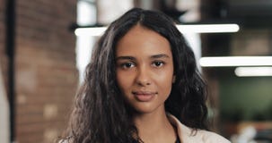 Stående av den unga lyckade affärskvinnan på det upptagna kontoret Stilig kvinnlig anställd som ser kameran och att le stock video Stående av den unga lyckade affärskvinnan på det upptagna kontoret Stilig kvinnlig anställd som ser kameran och att le stock video