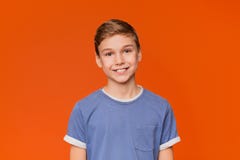 Stående av den unga pojken på orange bakgrund fotografering för bildbyråer Stående av den unga pojken på orange bakgrund fotografering för bildbyråer