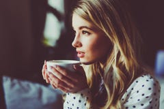 Stående av den unga ursnygga kvinnlign som dricker te och ser hänsynsfullt ut ur coffee shopfönstret, medan tycka om hennes friti royaltyfria foton Stående av den unga ursnygga kvinnlign som dricker te och ser hänsynsfullt ut ur coffee shopfönstret, medan tycka om hennes friti royaltyfria foton