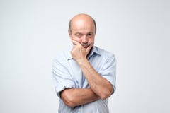 Stående av den äldre allvarliga mannen som gnider hans haka arkivfoton Stående av den äldre allvarliga mannen som gnider hans haka arkivfoton