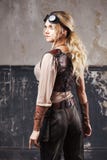 Stående av en härlig steampunkkvinna i flygareexponeringsglas över grå bakgrund Arkivfoto Stående av en härlig steampunkkvinna i flygareexponeringsglas över grå bakgrund Arkivfoto