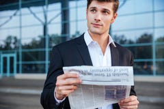 Stående av en hållande tidning för stilig affärsman utomhus arkivfoton Stående av en hållande tidning för stilig affärsman utomhus arkivfoton
