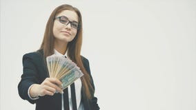 Stående av kläder för ett kontor för lycklig ung flicka som bärande rymmer fanpengar på en långsträckt hand lager videofilmer Stående av kläder för ett kontor för lycklig ung flicka som bärande rymmer fanpengar på en långsträckt hand lager videofilmer