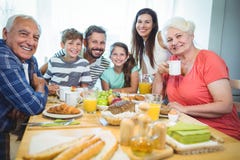 Stående av lyckligt mång--utveckling familjsammanträde på frukosttabellen arkivfoto Stående av lyckligt mång--utveckling familjsammanträde på frukosttabellen arkivfoto