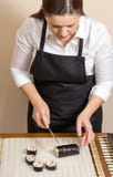 Stående av rulle för sushi för kvinnakock bitande japansk Royaltyfri Foto Stående av rulle för sushi för kvinnakock bitande japansk Royaltyfri Foto