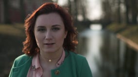 Ståendeslut upp framsidan - ung kvinna som kopplar av nära en slottdelkanal under en bärande gräsplan för varmt vårväder lager videofilmer Ståendeslut upp framsidan - ung kvinna som kopplar av nära en slottdelkanal under en bärande gräsplan för varmt vårväder lager videofilmer