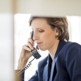 Successful young businesswoman sitting at her desk making a phone call royalty free stock photo Successful young businesswoman sitting at her desk making a phone call royalty free stock photo