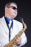 Sueño del saxofonista masculino Posing In Sunglasses con el saxofón imagen de archivo Sueño del saxofonista masculino Posing In Sunglasses con el saxofón imagen de archivo