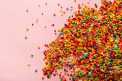 Colorful sprinkles scattered on pink background stock images Colorful sprinkles scattered on pink background stock images
