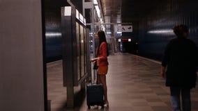 Sul viaggio di affari Un capo femminile aspetta il suo treno e considera l'orario archivi video Sul viaggio di affari Un capo femminile aspetta il suo treno e considera l'orario archivi video