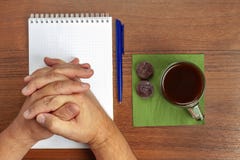Sulla tavola si trova una penna, il taccuino, il tè, dolci durante i negoziati immagine stock Sulla tavola si trova una penna, il taccuino, il tè, dolci durante i negoziati immagine stock