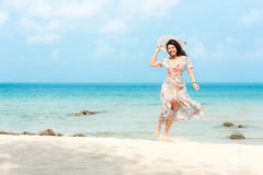 Summer Holiday. Lifestyle smiling asian woman wearing dress fashion summer trips relax on the sandy ocean beach. Happy woman enjoy stock image Summer Holiday. Lifestyle smiling asian woman wearing dress fashion summer trips relax on the sandy ocean beach. Happy woman enjoy stock image