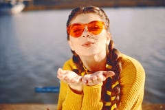 Summer holidays concept - happy woman sends sweet air kiss. Sprint positive portrait of happy cheerful young woman. Wearing yellow royalty free stock photography Summer holidays concept - happy woman sends sweet air kiss. Sprint positive portrait of happy cheerful young woman. Wearing yellow royalty free stock photography
