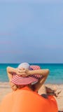 Summer lifestyle portrait of pretty girl sitting on the orange inflatable sofa on the beach of tropical island. Relaxing stock photo Summer lifestyle portrait of pretty girl sitting on the orange inflatable sofa on the beach of tropical island. Relaxing stock photo