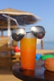 Summer oranhe shake coctail with straw and sun glasses on the se stock photos Summer oranhe shake coctail with straw and sun glasses on the se stock photos