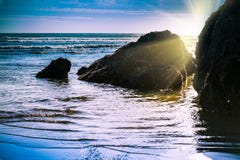 Sun setting behind rock formations in shallow water at the beach royalty free stock images Sun setting behind rock formations in shallow water at the beach royalty free stock images