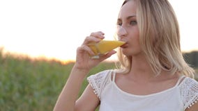 Sund kvinna som dricker orange fruktsaft och att le stock video Sund kvinna som dricker orange fruktsaft och att le stock video