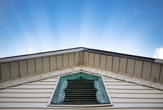 Sunlit лучи светя за выступленной крышей с деревенским голубым окном стоковое изображение Sunlit лучи светя за выступленной крышей с деревенским голубым окном стоковое изображение