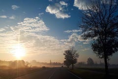 Sunrise on a foggy morning. The sun rises above the horizon and illuminates the road royalty free stock images Sunrise on a foggy morning. The sun rises above the horizon and illuminates the road royalty free stock images