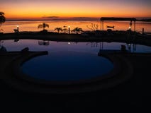 Sunset with a boat and palm trees reflected in the pool stock photography Sunset with a boat and palm trees reflected in the pool stock photography