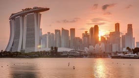 Sunset over the downtown skyline of Singapore as viewed from across the water from The Garden East timelapse. Singapore.